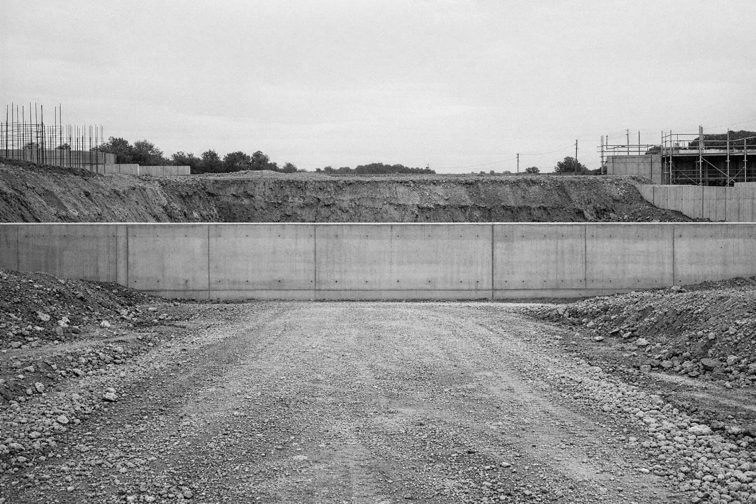 Mur de soutènement en béton et plateforme de terrassement, en noir et blanc.